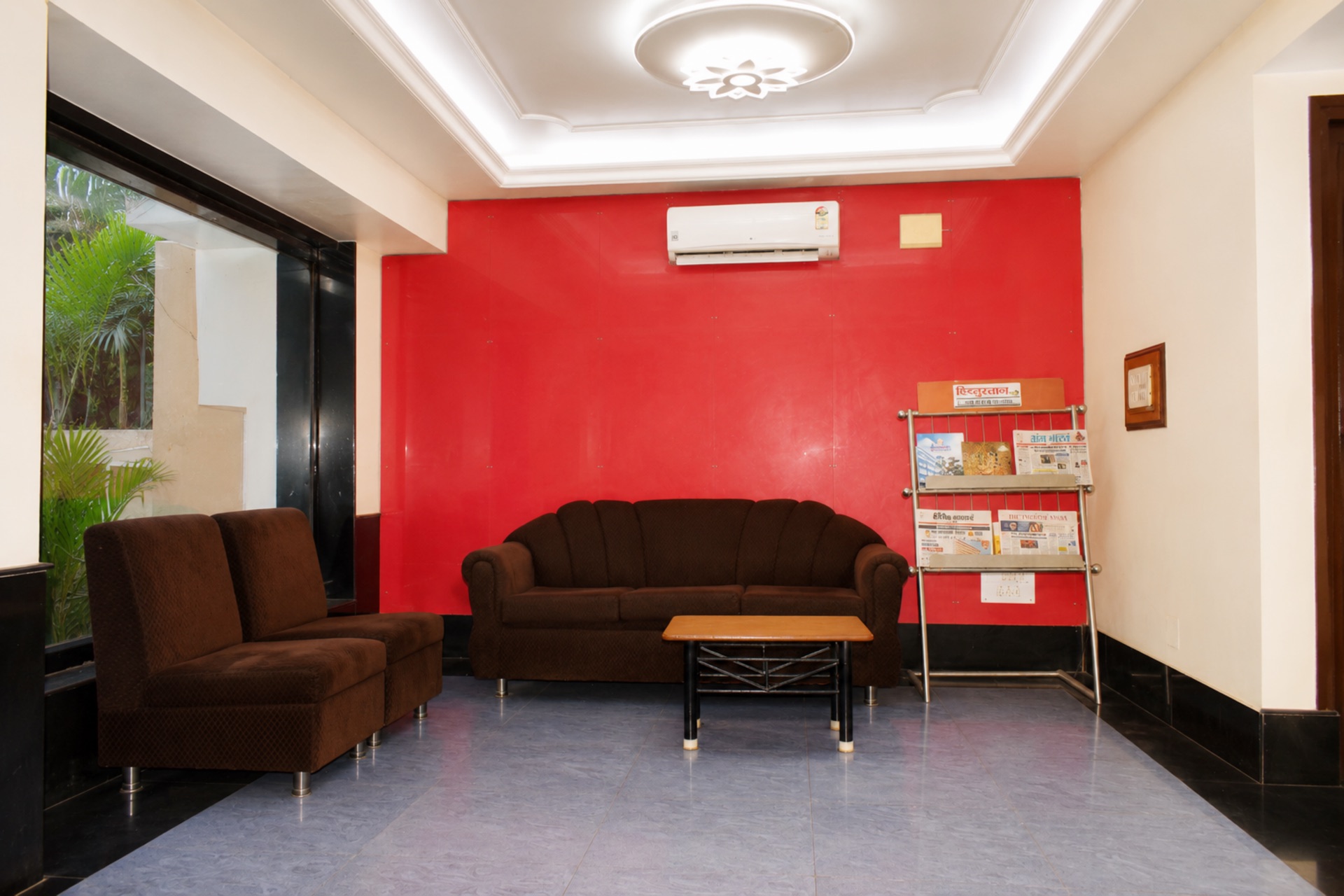Guest arrival waiting lounge with sofa seating, garden window and newspaper stand